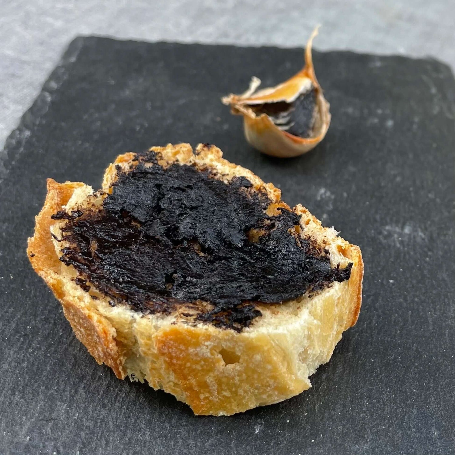 Ail noir sur un morceau de pain